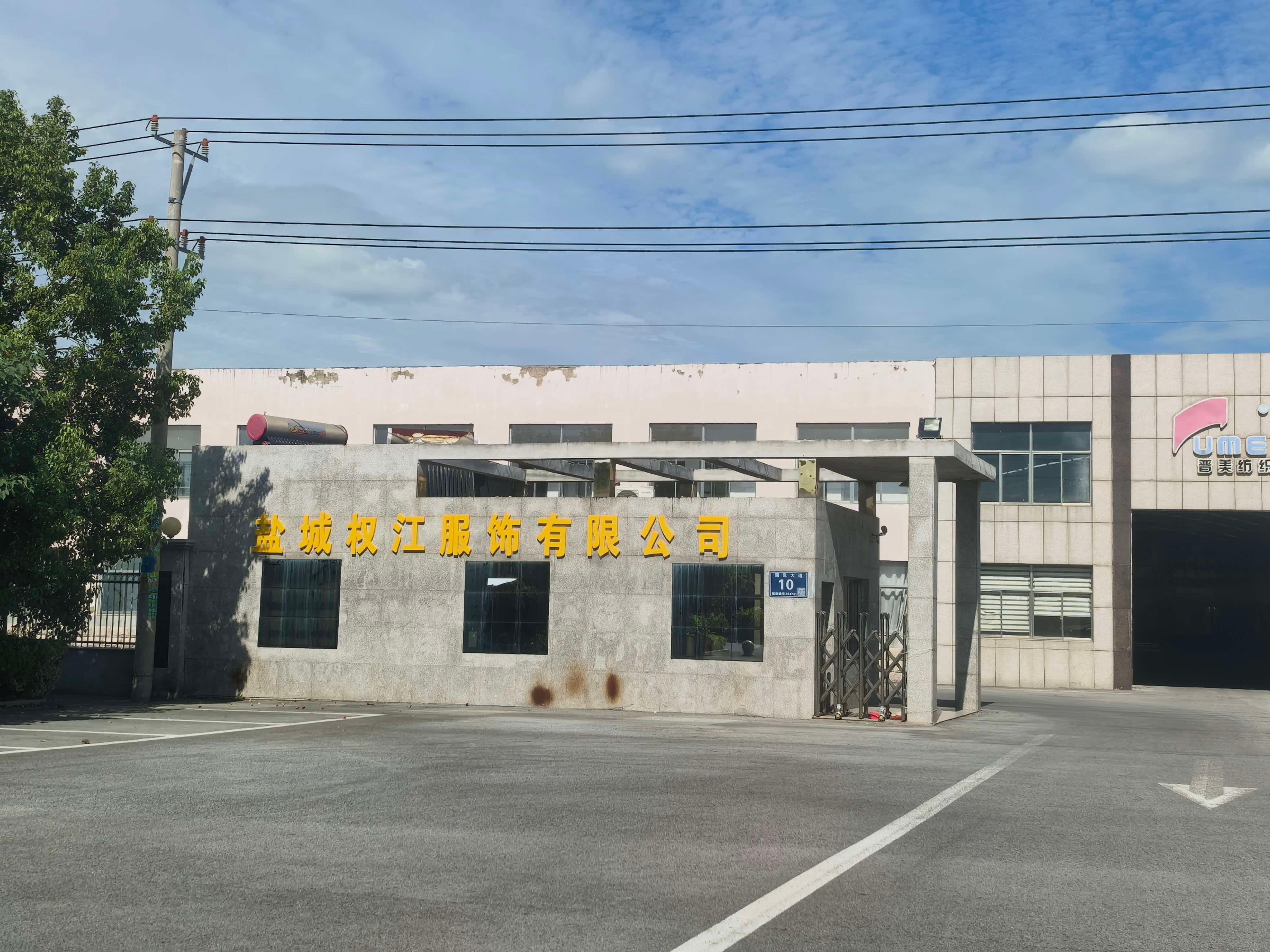 Factory gate building with the company name in Chinese characters above the entrance